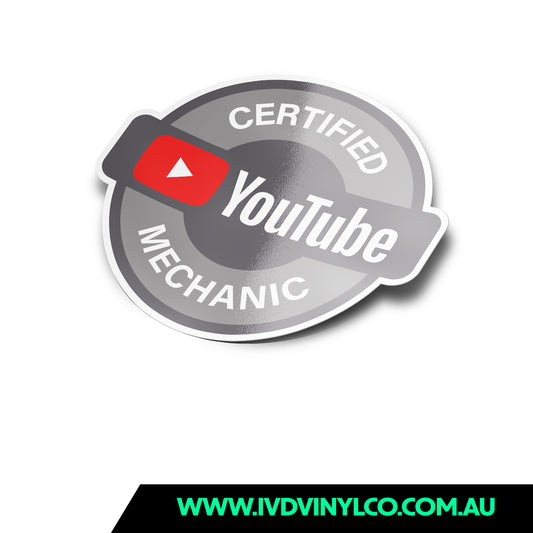 A round sticker with the text 'CERTIFIED MECHANIC' and the YouTube logo, predominantly silver and white with a red play button icon.